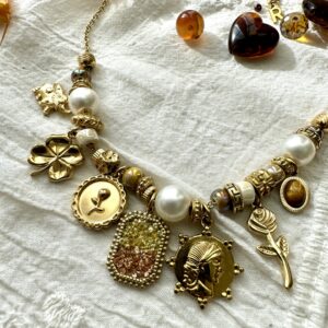 Collier doré avec ses perles blanches et ses breloques dorées