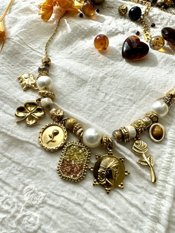 Collier doré avec ses perles blanches et ses breloques dorées